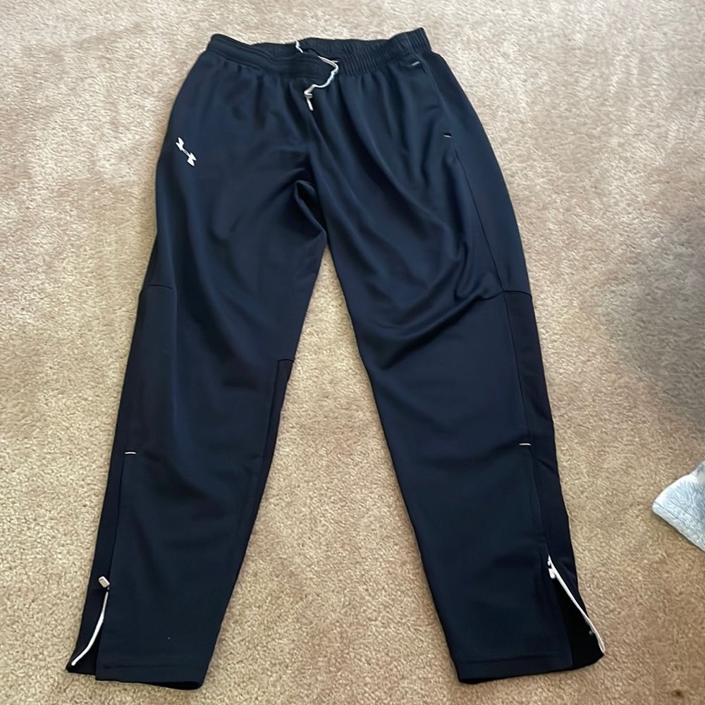 Under Armour joggers with zip bottoms.